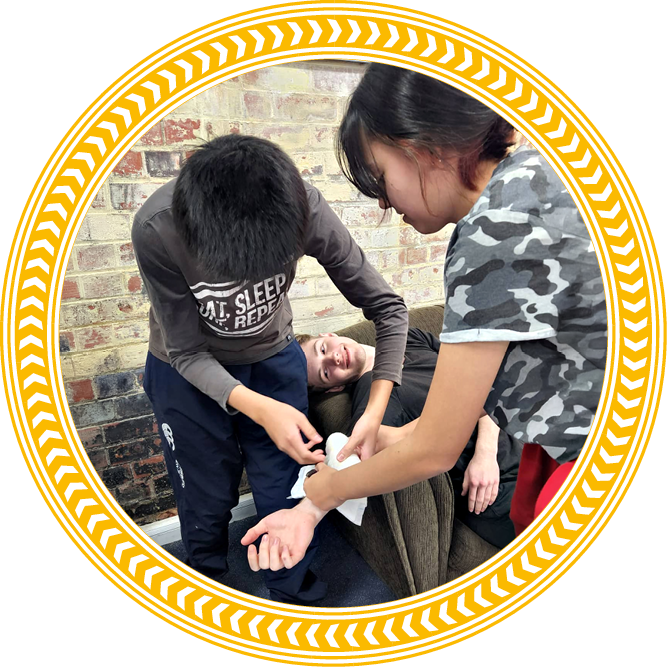 Students and ambulance officer carrying a student on a stretcher